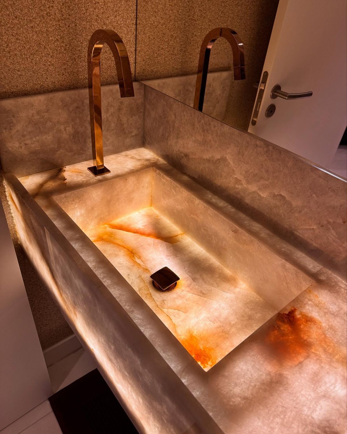Lavabo em ônix translúcido iluminado executado pela Oliveira