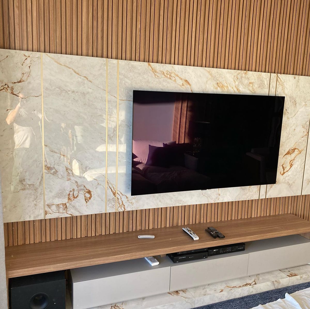 Painel de TV em porcelanato com ripado executado pela Oliveira